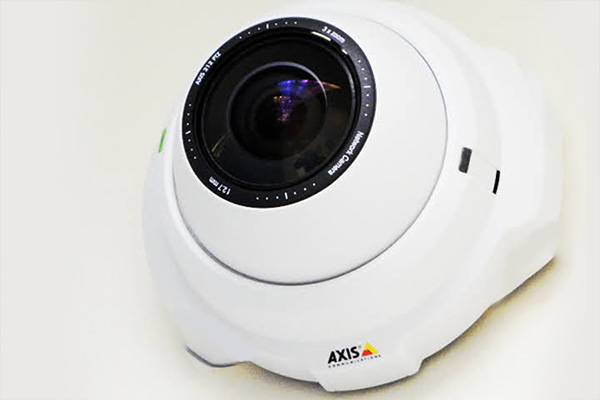 White Axis Mega Pixel Security Camera on a White Wall Background